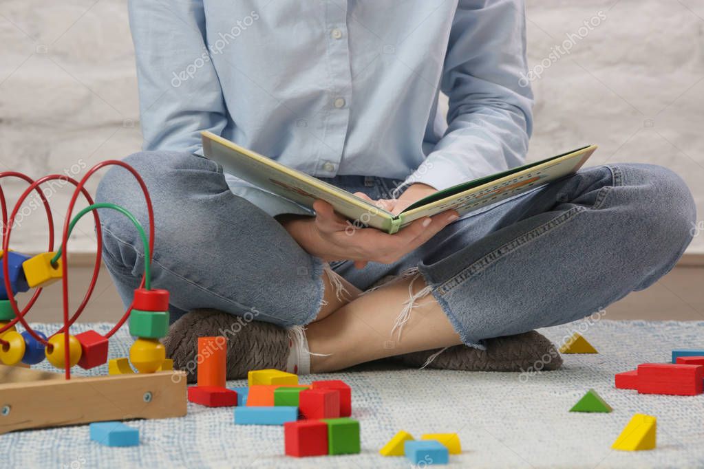 Porträt einer lächelnden Spielgruppenleiterin in einem bunten Gruppenraum