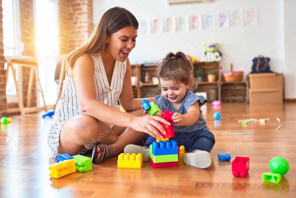 Spielgruppenleiterin spricht mit einer Mutter beim Abholen eines Kindes