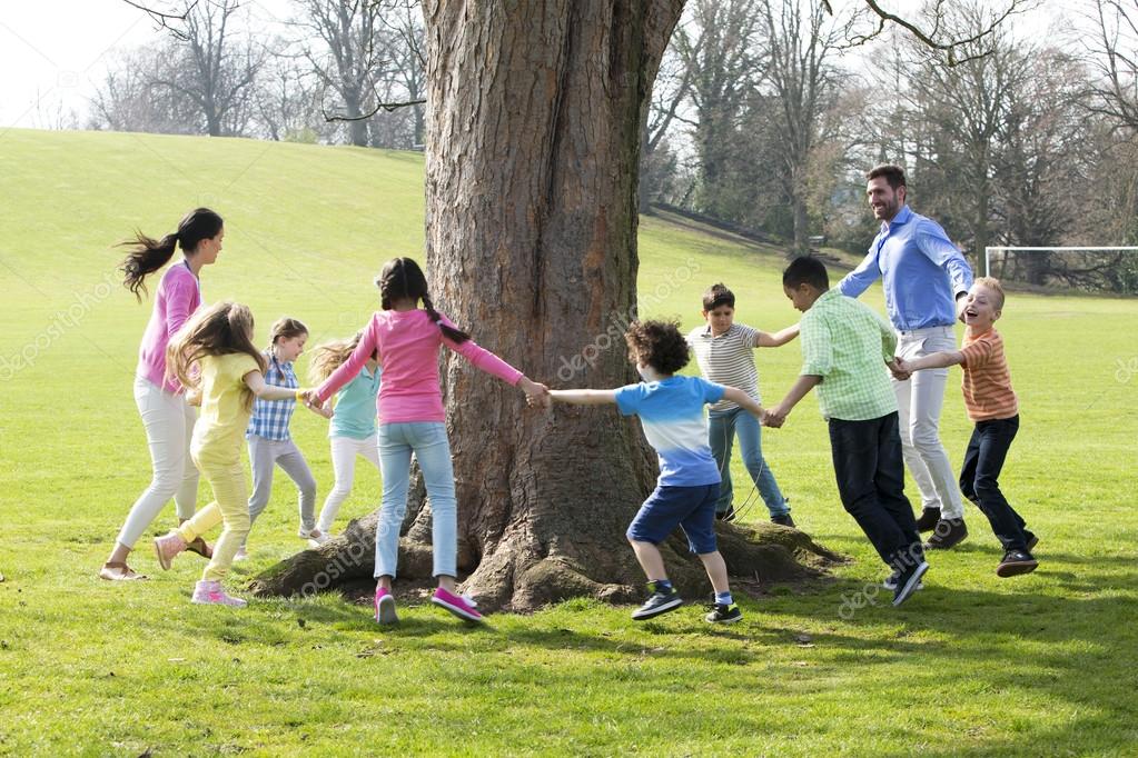 Kinder sitzen im Kreis und hören einer Betreuerin zu